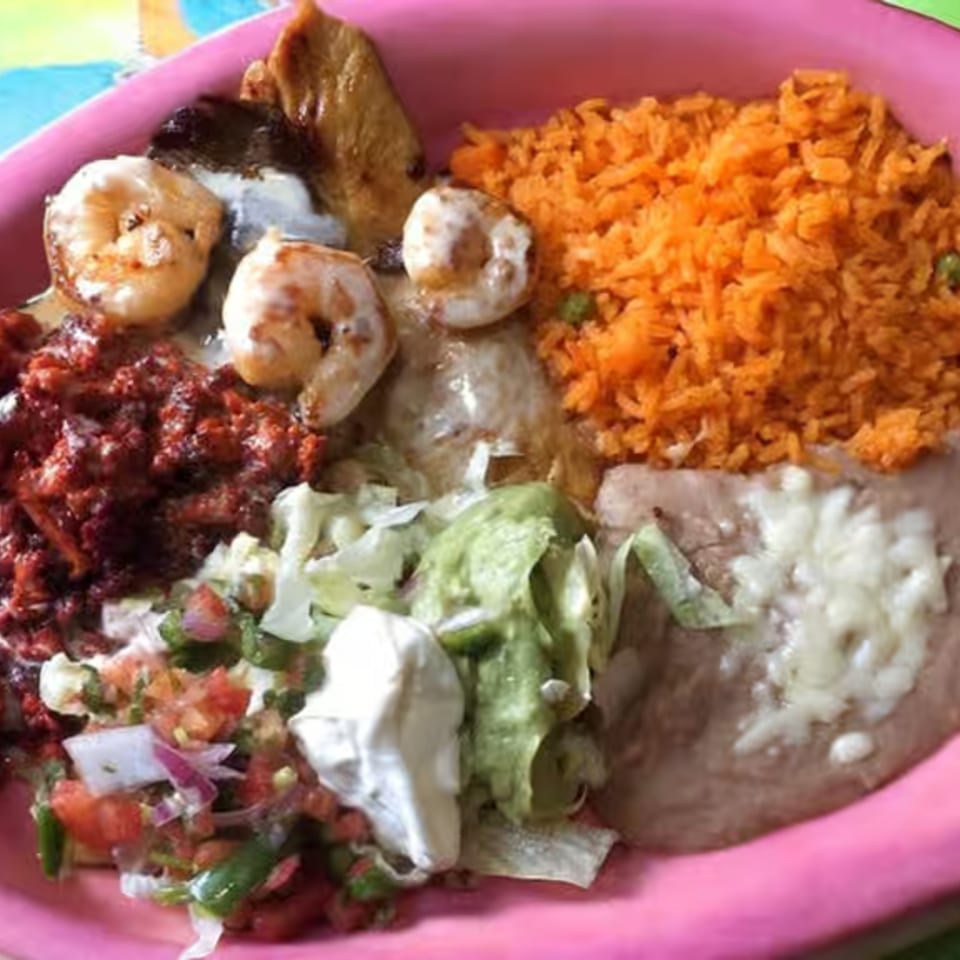 La Casita's Mexican combo plate with shrimp, red rice, refried beans, guacamole, pico de gallo, and sour cream.