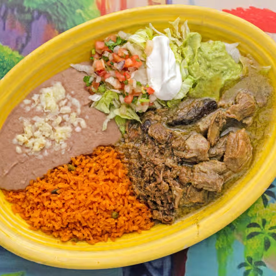 La Casita's Mexican dish with rice, refried beans, stewed meat, guacamole, pico de gallo, and sour cream.